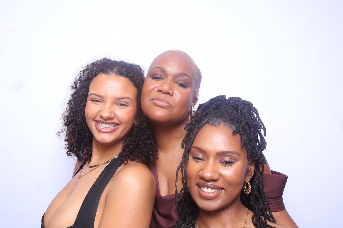 Three guests smiling together in the photo booth